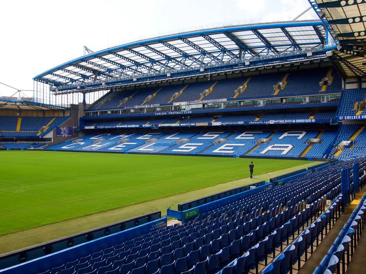 Bên trong sân Stamford Bridge nhìn từ khán đài chính, sân cỏ xanh mướt và hàng ghế màu xanh đặc trưng của Chelsea