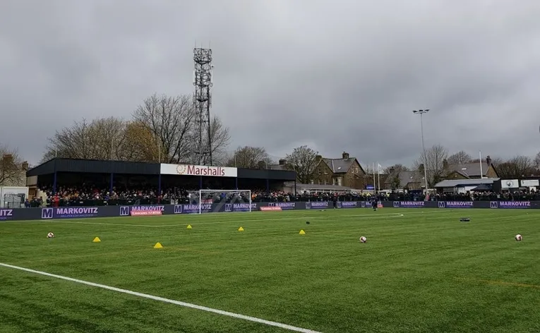 Khán đài Railway End có mái che tại sân Silverlands, nơi cổ động viên Buxton FC thể hiện tình yêu bóng đá.